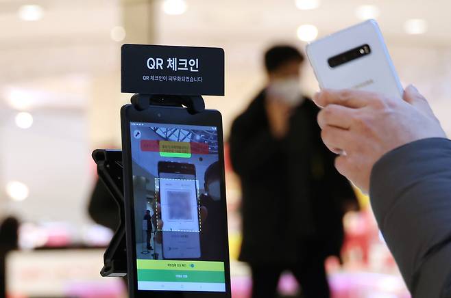 The mandate requires people to scan QR codes containing personal information including vaccination status before entering public places. (Yonhap)