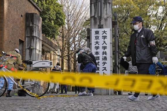일본 경찰들이 15일 일본 도쿄대 인근에서 발생한 흉기 난동 사건 현장을 점검하고 있다. 고교 2학년생이 무차별적으로 휘두른 칼에 대입 시험을 치러 향하던 고교생 2명과 72세 노인이 찔렸다. AP뉴시스