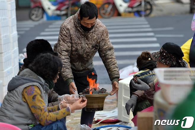 경북 포항시 북구 죽도시장에서 상인들이 모닥불에 몸을 녹이고 있다. 2021.11.23/뉴스1 © News1 최창호 기자