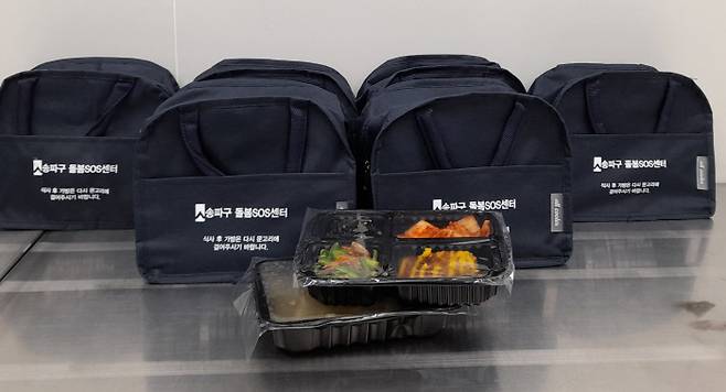 송파구가 돌봄SOS센터 식사 지원 서비스에 비닐봉투 대신 ‘다회용 보냉백’으로 배달을 시작했다. 가방에는 ‘식사 후 가방은 다시 문고리에 걸어주시기 바랍니다’라고 적혀있다. | 송파구 제공