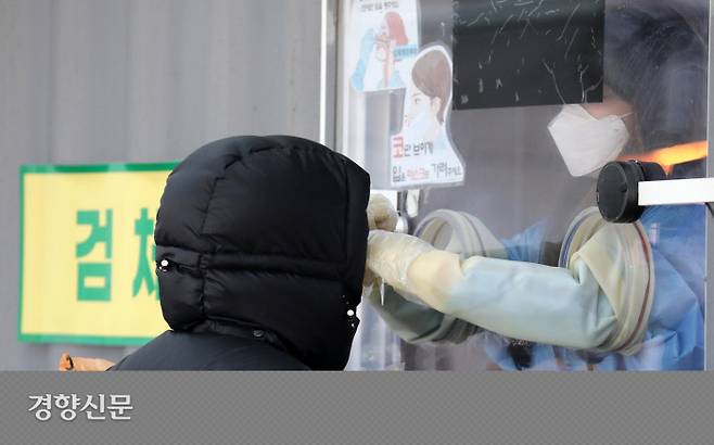 서울시 코로나19 확진자 중 오미크론 변이가 검출되는 비율이 26.7%를 기록하고 있는 가운데 17일 서울광장 임시선별검사소에서 방한복 모자를 쓴 한 시민이 검체를 채취하고 있다. 박민규 선임기자