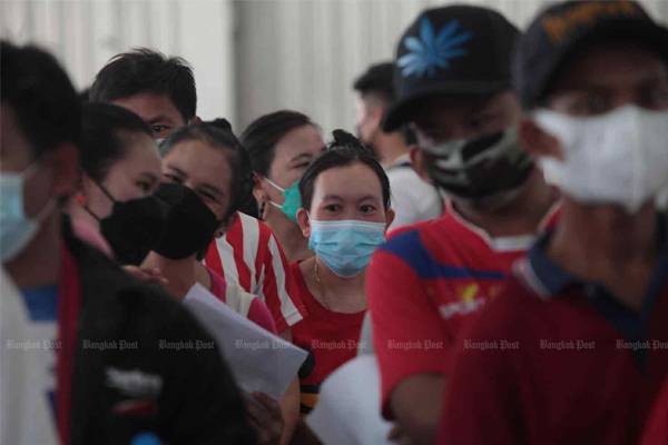 Migrant workers from Myanmar, Laos and Cambodia wait to get their first shot of Sinovac vaccine at Bang Yai market in Nonthaburi on Oct 30, 2021. Apichart Jinakul