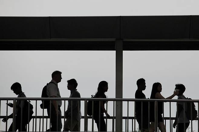 Office workers cross a pedestrian bridge in the Siam area. Thailand"s unemployment rate is worrying the Employers" Confederation of Thai Trade and Industry (EconThai) as it rapidly soared to 4.58% or around 1.77 million unemployed people, the highest in a decade, following two years of the pandemic. Wichan Charoenkiatpakul