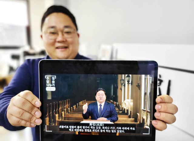 민대홍 목사가 지난 14일 경기도 파주 서로교회에서 테블릿 PC를 통해 이 교회 온라인 예배 영상을 보여주며 환하게 웃고 있다.