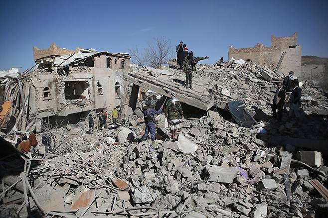 예멘 주민들이 18일 후티 반군이 점령한 사나에서 사우디아라비아 주도 연합군의 공습으로 파괴된 건물 잔해를 둘러보고 있다. 사나/AP 연합뉴스