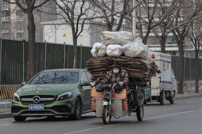 20일 중국 베이징에서 한 남성이 폐지 등 재활용 물품을 오토바이에 실어 나르고 있다./EPA 연합뉴스