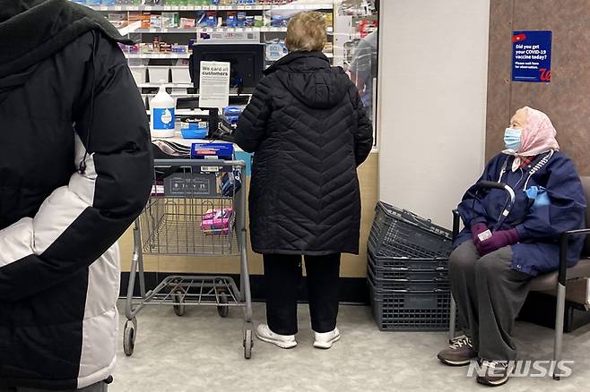 [AP/뉴시스] 14일 미국 일리노이주 프로스펙스 하이츠의 월글린 약국체인점에서 주민들이 코로나19 백신 주사를 기다리고 있다