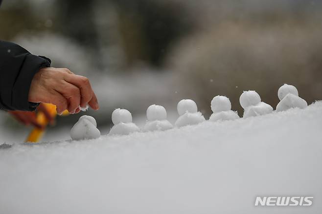 [서울=뉴시스] 정병혁 기자 = 지난 19일 오전 서울 용산구 용산역에서 한 시민이 눈오리를 만들고 있다. 2022.01.19. jhope@newsis.com
