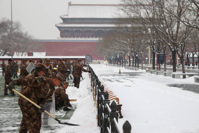 22일(현지시간) 중국 베이징에서 코로나19 확산이 계속되고 있는 가운데 인민무력경찰대(PAP) 군인들이 자금성에서 밤새 내린 눈을 치우고 있다. / 사진 =연합뉴스