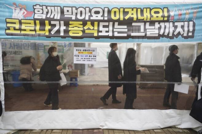코로나19 신규 확진자가 8571명으로 역대 최다를 기록한 25일 서울 마포구 서강대역 인근 임시선별검사소를 찾은 시민들이 검사를 받기 위해 줄 서 있다. 임형택 기자
