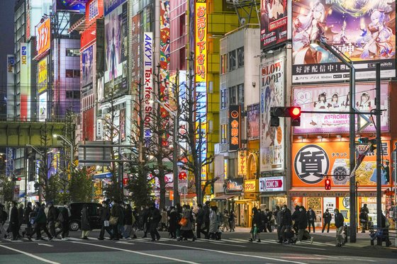 26일 저녁 마스크를 쓴 시민들이 일본 도쿄 중심가를 지나고 있다. [AP=연합뉴스]