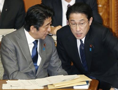 2015년 1월 28일 일본 참의원 본회의에서 아베 신조 당시 일본 총리와 기시다 후미오 당시 외무상이 대화하고 있다. 교도 연합뉴스 자료사진.