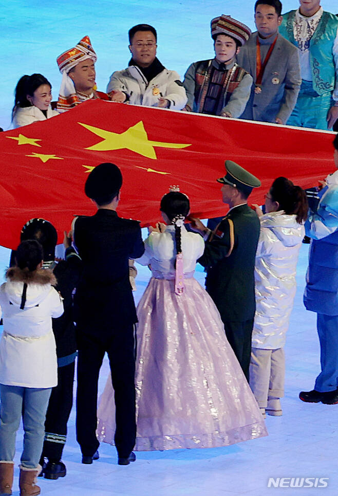 [베이징(중국)=뉴시스] 김병문 기자 = 지난 4일 오후 중국 베이징 국립 경기장에서 열린 2022 베이징 동계올림픽 개막식에서 한복을 입은 한 공연자가 중국 국기인 오성홍기 입장식에 참여하고 있다. 2022.02.05. dadazon@newsis.com