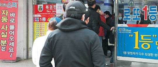 로또를 사기 위해 복권 판매점에 시민들이 줄지어 서 있다. 뉴시스
