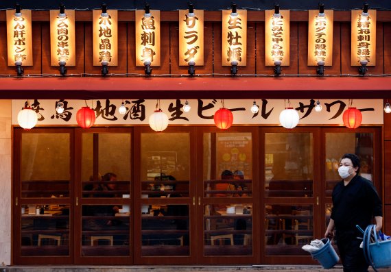 지난 9일 일본 도쿄의 한 음식점 앞으로 한 남성이 지나가고 있다. 로이터 뉴스1
