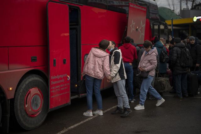 우크라이나 여성이 24일(현지시간) 수도 키예프를 벗어나는 버스에 오르기 전 연인으로 보이는 남성과 작별의 키스를 나누고 있다. AP/뉴시스