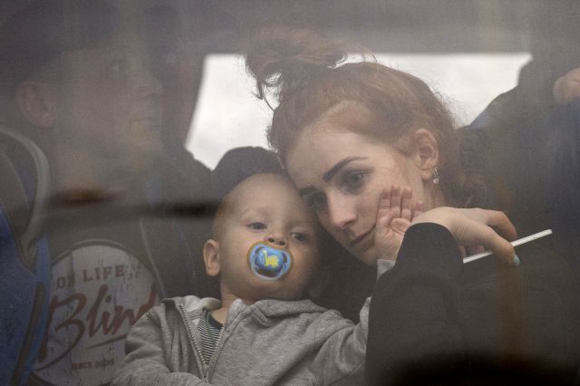 우크라이나 수도 키예프를 떠나는 버스에 탑승한 한 여성이 24일(현지시간) 고무 젖꼭지를 물고 있는 아기를 안은 채 창밖을 불안한 표정으로 바라보고 있다. AP/뉴시스