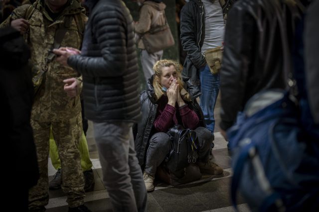 우크라이나 수도 키예프를 떠나는 기차를 기다리는 한 여성이 24일(현지시간) 바닥에 주저 앉아 있다. AP/뉴시스
