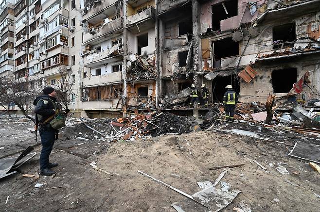 25일(현지시간) 우크라이나 수도 키예프시 한 교외 아파트단지가 러시아군의 마시일 폭격을 받아 외벽이 무너져 내린 모습. 러시아의 전면 공격으로 주민 10만명이 도시를 떠나 대피한 것으로 알려졌다. [AFP]