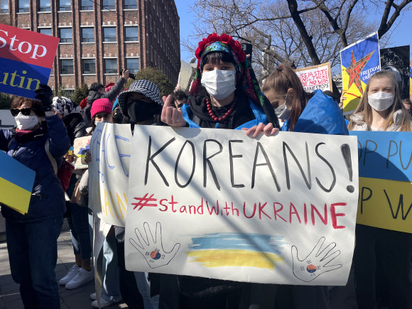 주한러시아대사관 인근서 열린 러시아 규탄 집회 - 한국에 사는 우크라이나인들과 이에 연대하는 한국인 300여 명이 27일 서울 중구 주한러시아대사관 인근에서 집회를 열고 러시아의 우크라이나 침공을 규탄하며 한국의 지지를 호소했다.     사진은 이날 규탄 집회에서 피켓을 들고 기념 촬영하는 참가자. 2022.2.27 연합뉴스