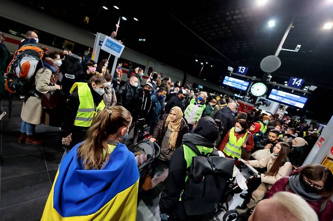 우크라이나 국기를 두른 시민을 비롯한 자원봉사자들이 2일(현지시간) 베를린 중앙역에 도착한 우크라이나 피란민들을 돕고 있다. / 로이터연합뉴스
