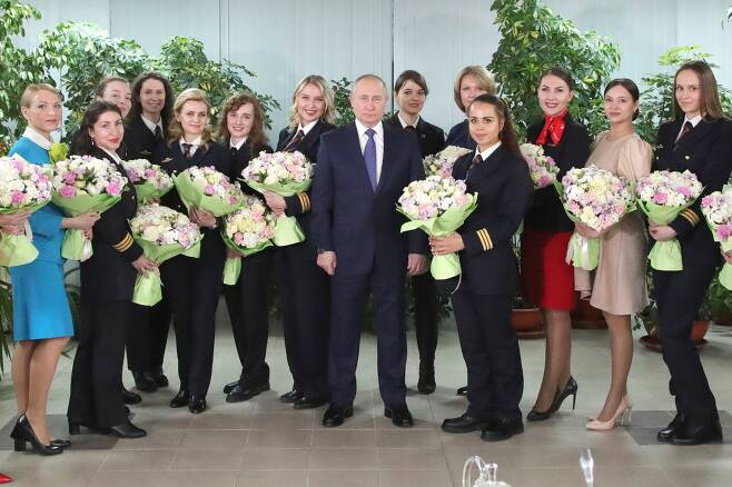 블라디미르 푸틴 러시아 대통령이 5일 세계 여성의 날을 앞두고 모스크바 근교에 있는 국영항공사 아에로플로트 항공학교를 방문해 여승무원과 기념사진을 찍고 있다. 타스=연합뉴스