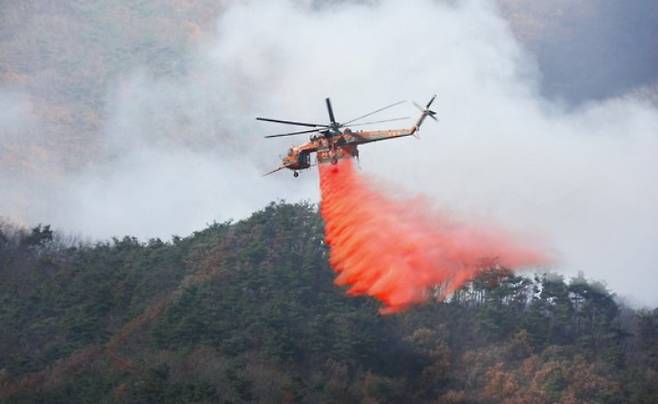 헬기가 산불 지연제인 리타던트를 공중에서 뿌리고 있다. 산림청 제공