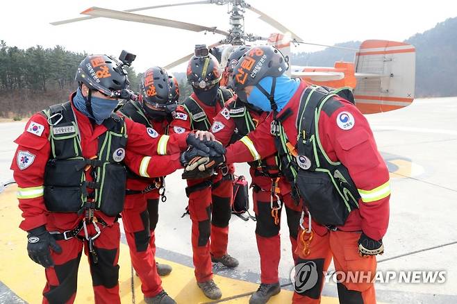 힘차게 출발 (울진=연합뉴스) 손대성 기자 = 12일 경북 울진군 기성면 울진산림항공관리소에서 산림항공본부 소속 공중진화대원들이 울진 응봉산 산불 현장에 헬기에서 줄을 타고 내려가는 레펠 방식으로 진입하기 위해 함께 모여 응원하고 있다. 2022.3.12 sds123@yna.co.kr