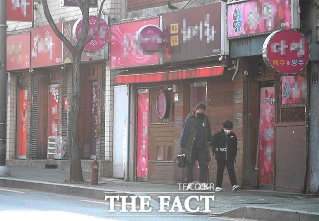 22일 서울 중랑구의 한 초등학교 일대. 부모님 손을 잡고 등교하는 초등학생 뒤로 일명 '방석집'이 줄지어 있다./이덕인 기자