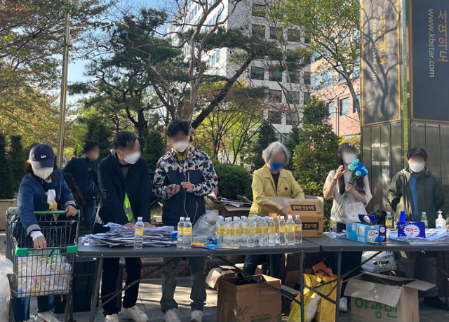 16일 국민은행 서여의도점 앞 '밭갈이운동본부'가 주최한 집회에서 4050 시민들이 물과 간식 등을 나누어주고 있다. 소진영 인턴기자