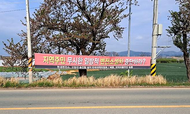 마을에 설치된 변전소, 송전탑 설치에 반대하는 현수막