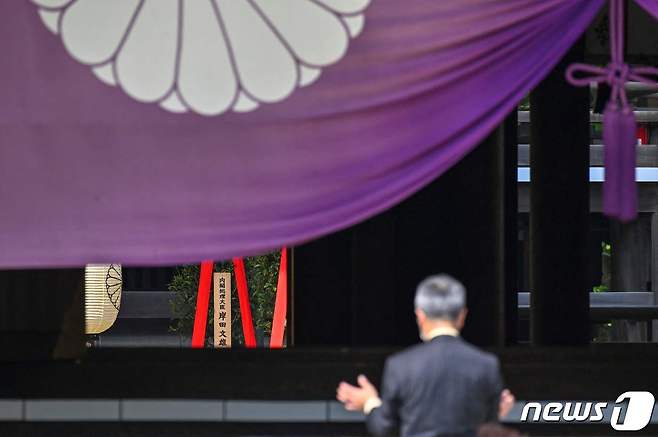 21일 (현지시간) 도쿄 야스쿠니 신사의 춘계 예대제 첫날에 기시다 후미오 일본 총리가 봉납한 공물 '마사카키' 앞에서 주민이 기원을 하고 있다. © AFP=뉴스1 © News1 우동명 기자