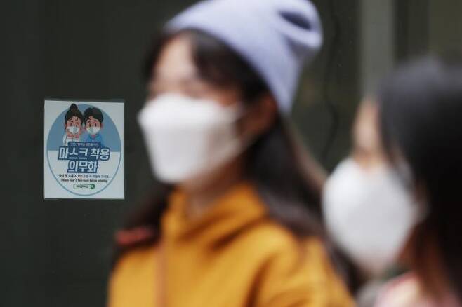 사진은 27일 오후 서울 중구 명동거리의 한 매장에 붙은 마스크 착용 의무화 안내문. 연합뉴스