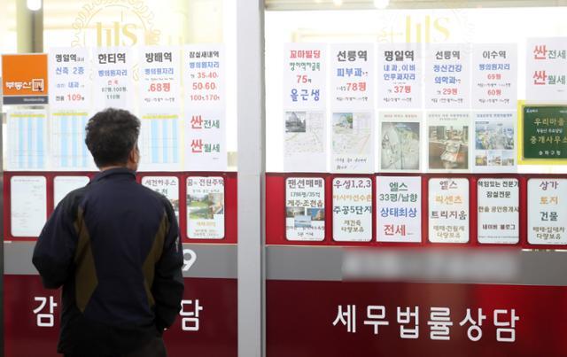 중년 남성이 서울의 한 부동산 중개업소에 걸린 매물 안내문을 보고 있다. 뉴시스