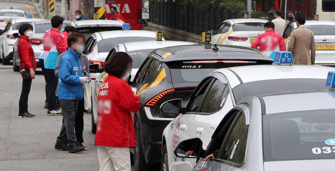 4월25일 강원도 춘천시에서 각 당의 지방선거 예비후보들이 택시 기사들에게 명함을 건네며 지지를 호소하고 있다.ⓒ연합뉴스