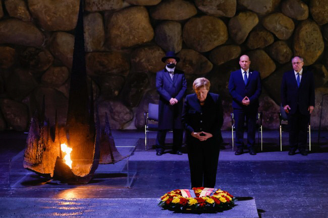 앙겔라 메르켈 전 독일 총리가 지난해 10월 이스라엘 예루살렘의 야드 바셈 홀로코스트 추모관에서 ‘영원의 불’을 밝히고 머리 숙여 참배하고 있다. 신화연합뉴스