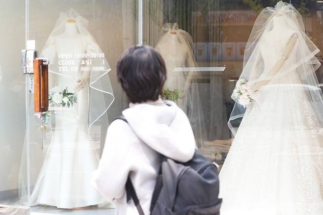A person walks past a shop window displaying bridal gowns in Mapo-gu, Seoul, April 19.