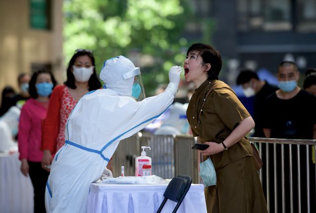 중국 베이징의 한 거리에서 15일 의료진이 코로나19 검사를 위해 한 여성의 검체를 채취하고 있다. 베이징은 지난달 25일 이후 일일 신규 감염자 수 30∼70명대를 유지하고 있다. AFP연합뉴스