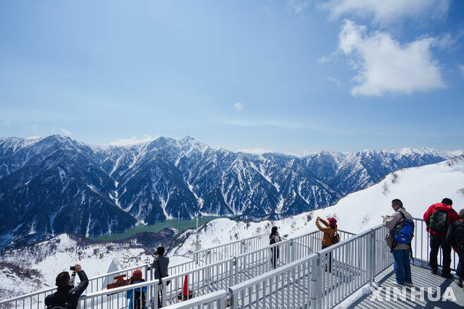 [나가노=AP/뉴시스] 일본 도야마현 다이칸보에 있는 설경 명승지를 3일 찾은 관광객들이 눈 쌓인 산을 배경으로 사진 촬영에 여념이 없다. 2022.05.12