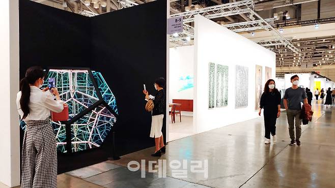 ‘아트부산 2022’의 오페라갤러리 전경. 프랑스 다국적 화랑인 오페라갤러리가 전시한 앤서니 제임스의 입체작품 ‘12면체 솔라 블랙’(2019) 앞에 관람객들이 오래 머물렀다. LED 조명과 유리 등이 뿜어내는 신비한 빛을 만든 작품은 아트페어 속 ‘미술관급 전시’ 중 하나였다(사진=오현주 문화전문기자).