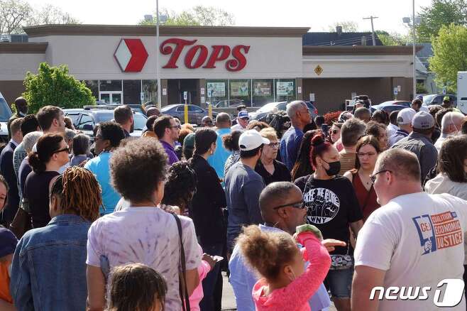 15일(현지시간) 총기 난사 사건이 발생한 미국 뉴욕주(州)의 슈퍼마켓 '탑스'(TOPS) 앞에 시민들이 모여있다. 이 사건으로 10명이 숨지고 3명이 다쳤다. © AFP=뉴스1 © News1 김예슬 기자