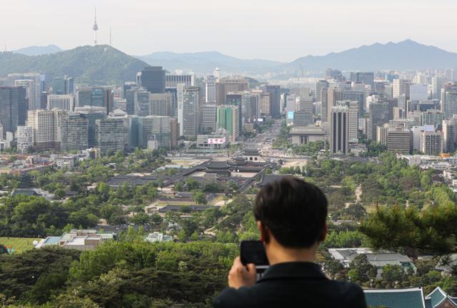 대통령 취임식 날인 10일 서울 종로구 청와대 춘추문이 열리며 등산로가 개방됐다. 청와대 전망대에 오른 시민이 사진을 담고 있다. 뉴시스