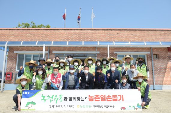 17일 충남 당진시 조금리 마을에서 농협유통 임직원 20여명이 농번기 일손 돕기에 앞서 기념사진을 찍고 있다. 농협유통 제공.