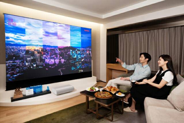 삼성전자 모델이 서울 광장동 워커힐 호텔앤리조트 내 '시네마 스위트 with 삼성 더 프리미어' 객실에서 프리미엄 빔 프로젝터 '더 프리미어'와 '더 프리미어' 전용 롤러블 스크린을 체험하고 있는 모습.(사진=삼성전자)