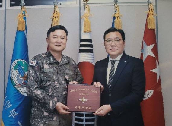 국방정보본부 최성목 정보기획부장(왼쪽)과 SNT모티브 특수사업본부 김택성 이사가 국방부장관 표창 수여식에서 기념사진을 찍고 있다./제공=SNT모티브