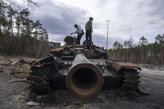 우크라이나 전쟁이 장기화되며 세계는 자유민주 진영과 권위주의 그룹으로 갈라지고 있다. 사진은 우크라이나 키이우 주민들이 전투 중 파손된 러시아 탱크에 올라간 모습. [AP=연합뉴스]