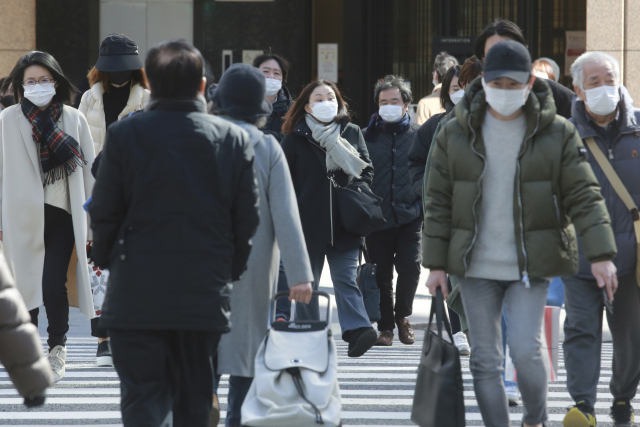 오미크론 변이가 급속히 번졌던 2월 일본 수도 도쿄에서 마스크를 쓴 시민들이 길을 걷고 있다. AP연합뉴스