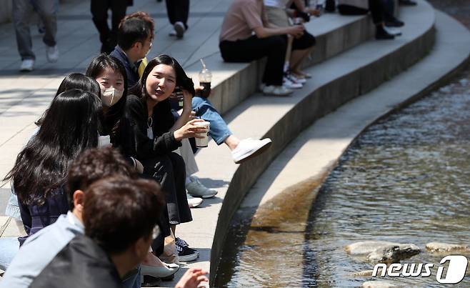 서울 청계천에서 마스크를 벗은 시민들이 음료를 마시며 휴식을 취하고 있다.© News1 박세연 기자