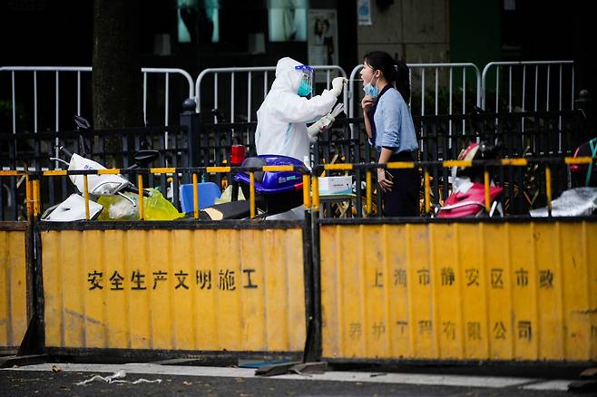 중국 상하이 거리에서 의료진이 코로나19 샘플을 채취하고 있다. [로이터]
