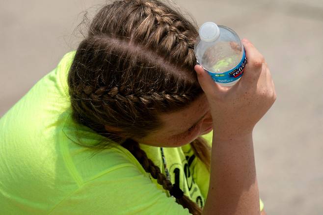 21일(현지시간) 미국 워싱턴 링컨기념관에서 한 관람객이 더위를 식히기 위해 물병을 머리에 대고 있다. 이날 워싱턴DC의 오후 최고 기온은 33도를 넘어섰다. AFP연합뉴스.